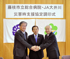 調印式で握手をしている男性3人の写真