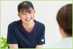 患者さんと向かい合い笑顔で話す看護師の写真