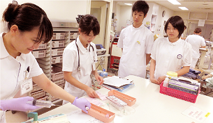 ナース体験をしている高校生が注射器の中に薬を詰めている写真