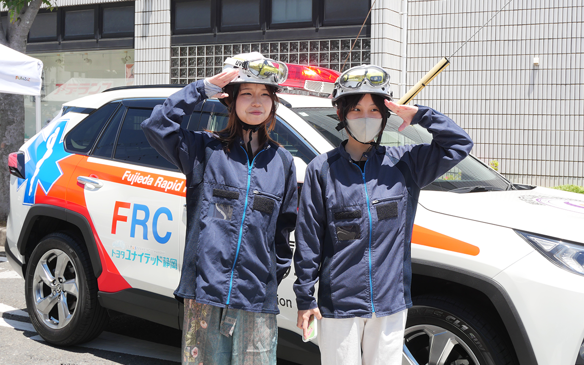 ラピッドレスポンスカーの前で写真を撮る女性