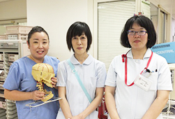 左に東部の骨格模型を持った青い制服の女性、その右に白い制服を着た2人の女性が並んでいる8B看護助手の写真